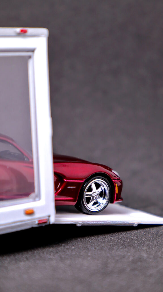 Auto World 2014 Dodge Viper peaking out of Greenlight glass trailer