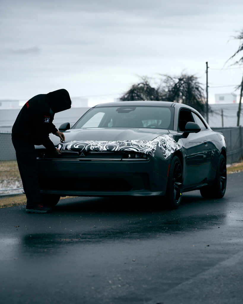 A man adjusting the camouflage on the new Charger EV